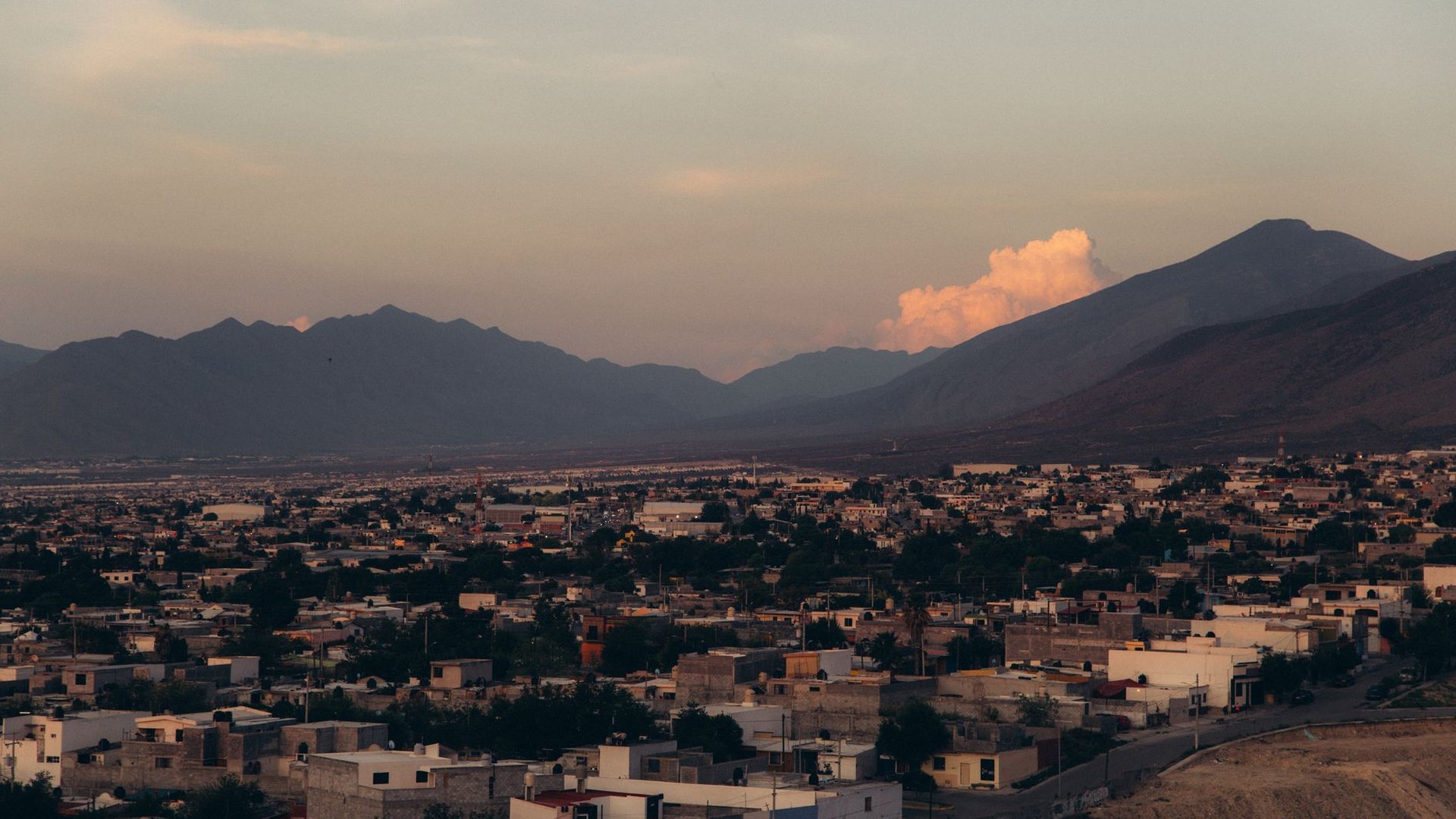 Barrio residencial al atardecer con la cordillera al fondo